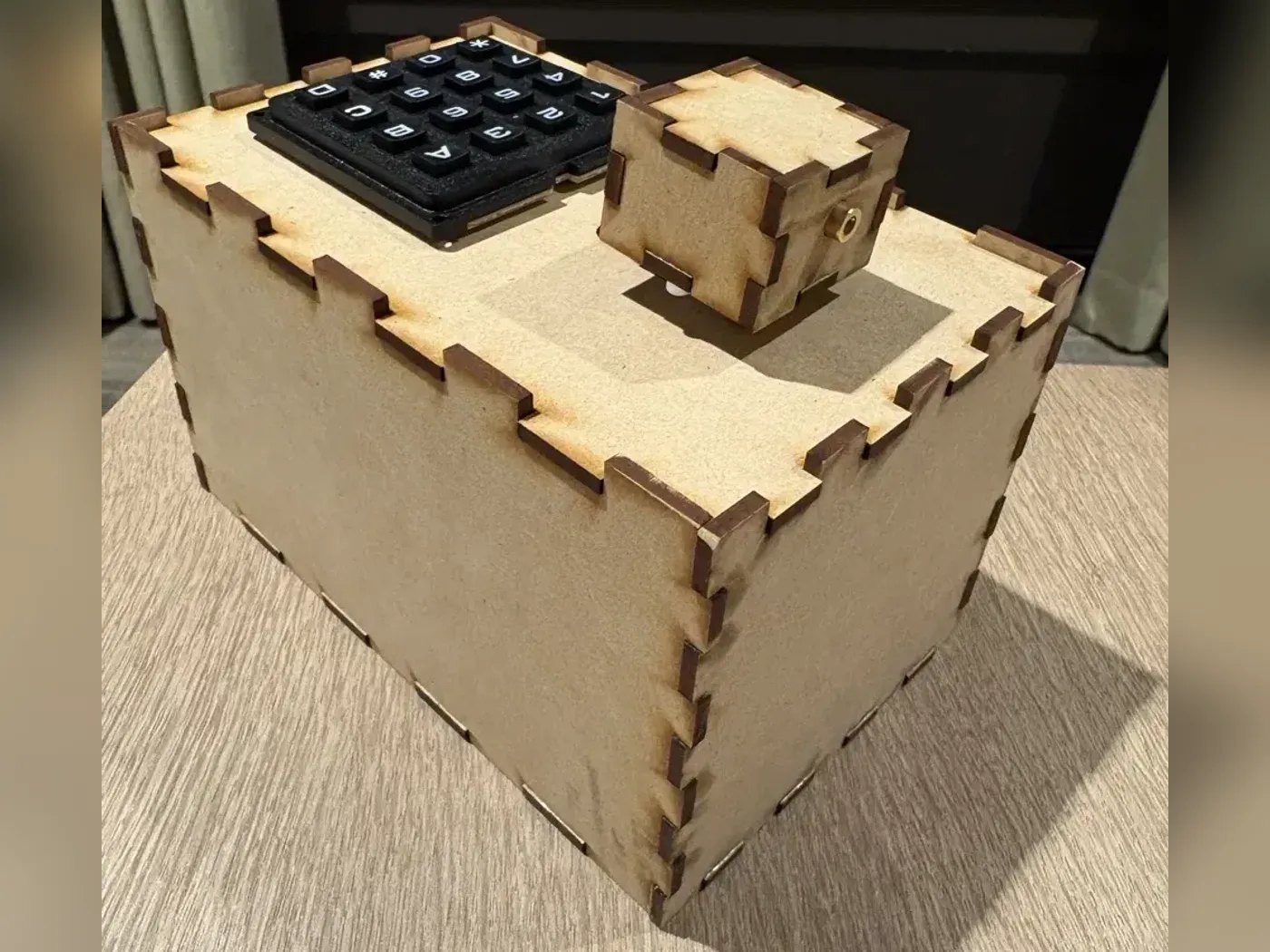 The transmitter, a laser-cut box with a 16-key keypad and a small servo-mounted laser housing on the lid
