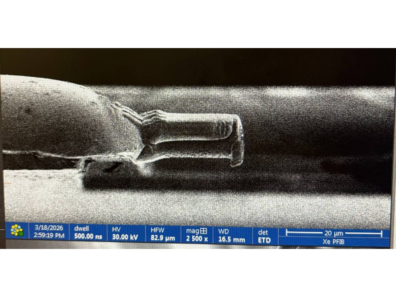 Scanning electron image from the Xe plasma FIB-SEM of a small specimen being prepared, at 2,500 times magnification